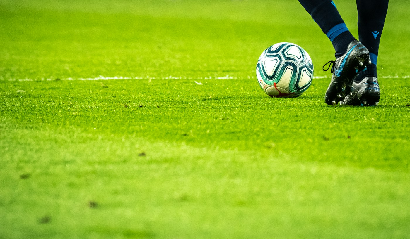 Futbolista controlando el balón sobre el césped