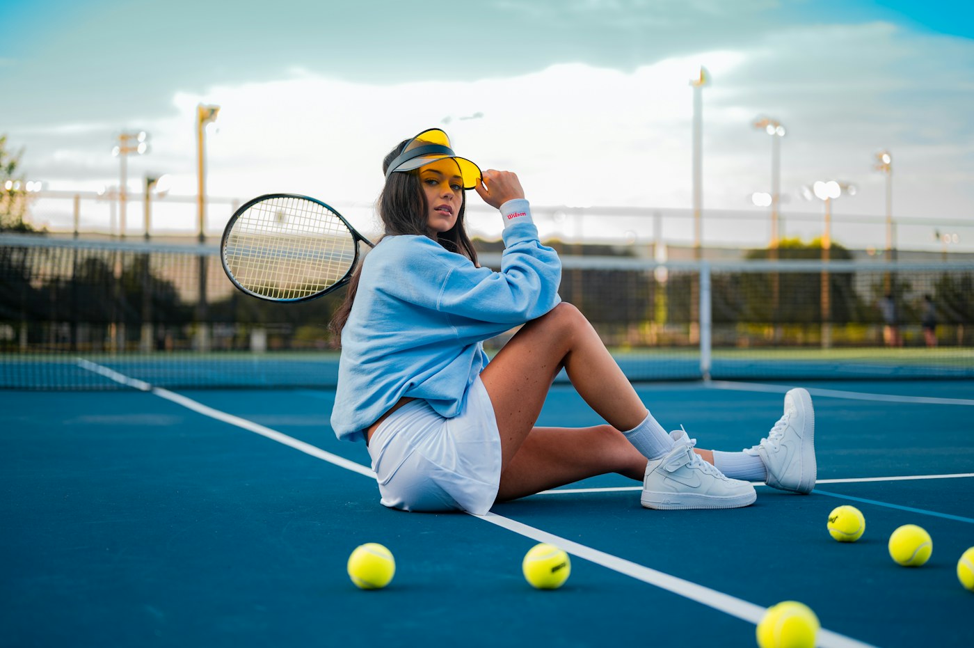Tenista con raqueta descansando junto a una pista de tenis